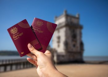 Holding two portuguese passports with a tower.